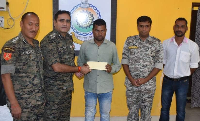 Chhattisgarh Police hands over a cheque to surrendered Maoist Sudhir Korsa on Wednesday as per rehabilitation policy. Debobrat Ghose