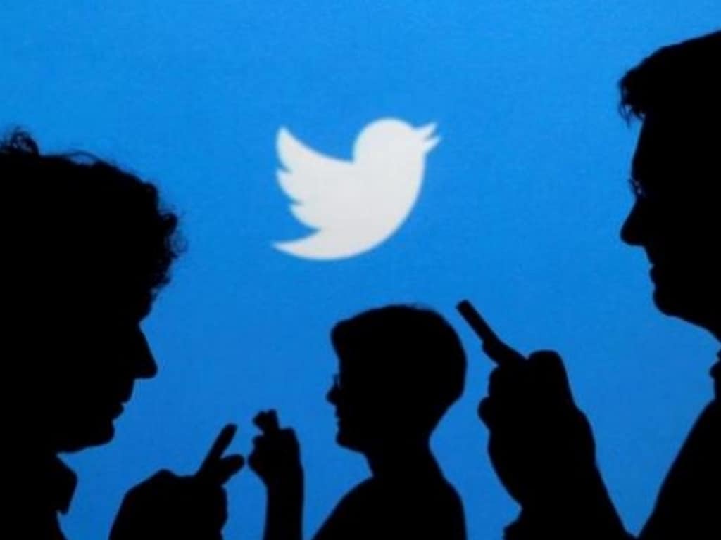 People holding mobile phones are silhouetted against a backdrop projected with the Twitter logo in this illustration picture taken in Warsaw September 27, 2013. Image: Reuters