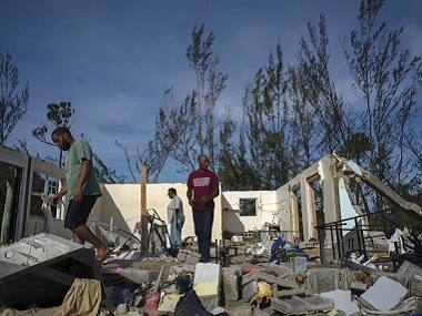 Residents survey damage caused by Hurricane Dorian. AP