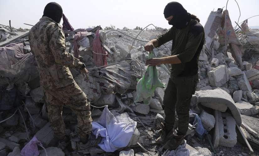 People look at a destroyed house near the village of Barisha in Idlib province of Syria after an operation by the US military which targeted Abu Bakr al-Baghdadi, the shadowy leader of the Islamic State group. AP