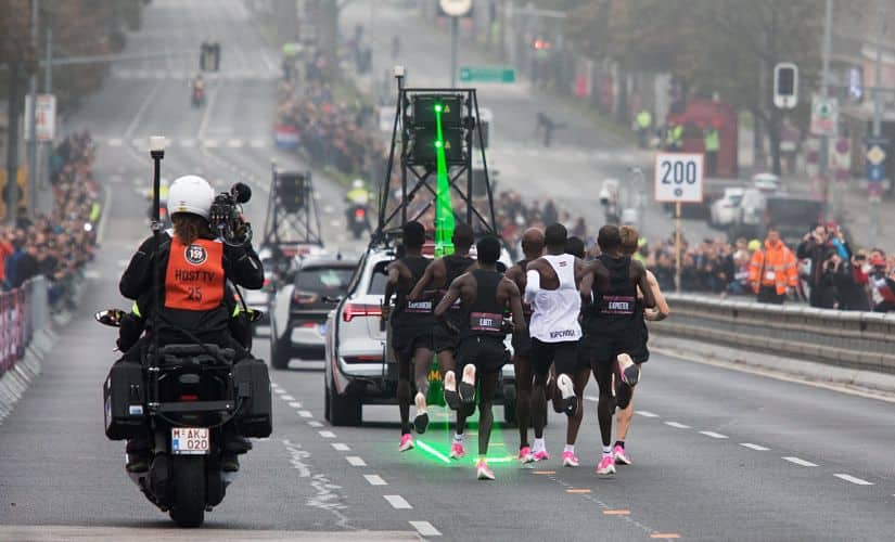 Eliud Kipchoge (white jersey) is surrounded by an armada of pacemakers and guided by a laser beam showing him the optimal running line during his attempt to run a marathon under two hours. AFP