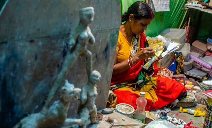 Mala Pal at her workshop, modelling a miniature Goddess Durga out of clay.