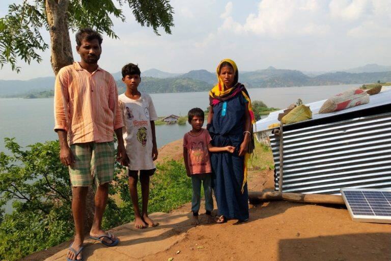 Ozabai and Divalya Vasave along with their kids in Bamani Village. The tin shed is their home right across the submerged one. Image credit: Kanchan Srivastava.