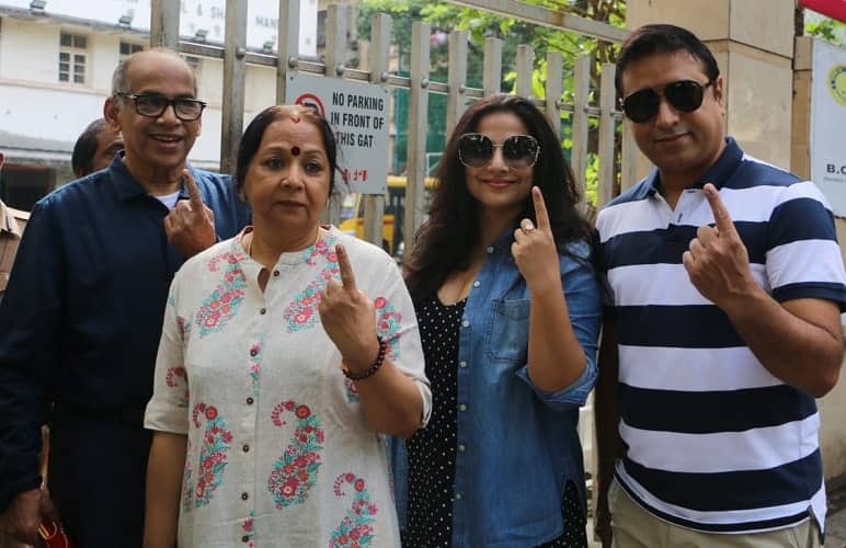 Vidya Balan and her family pose for photographers outside a polling booth in Mumbai