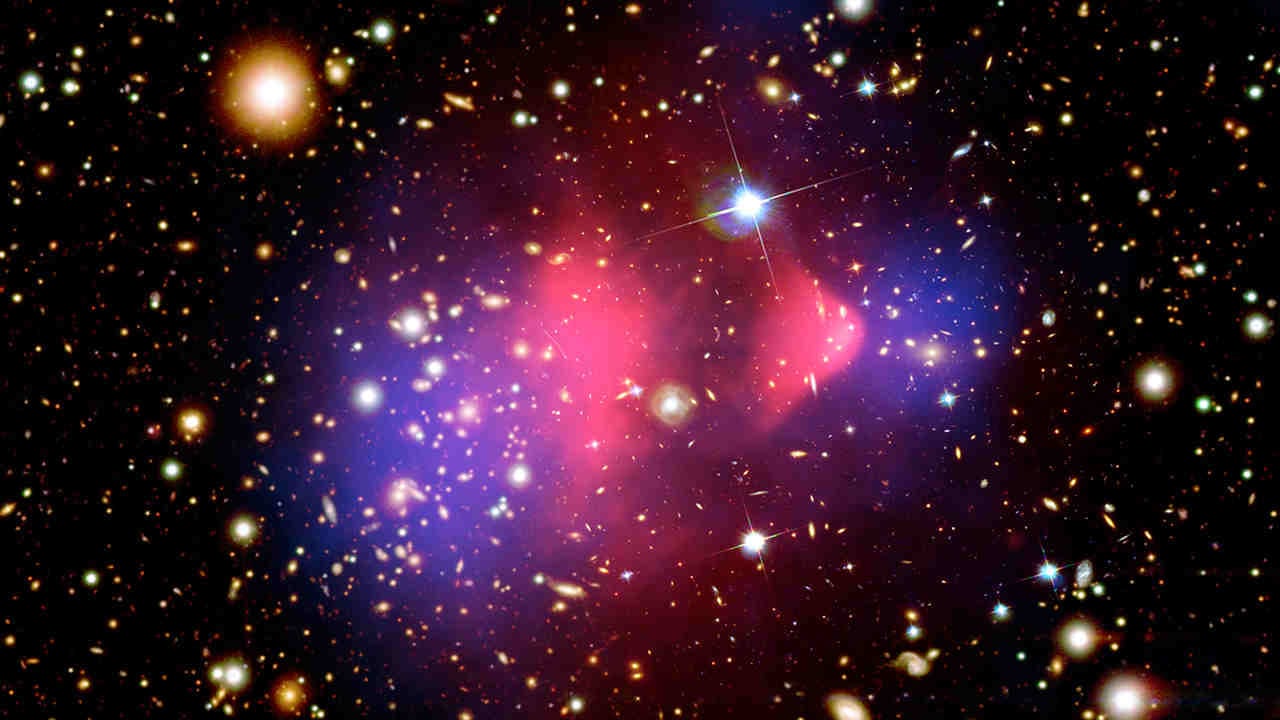 The deflection of light by gravity reveals dark matter in colliding clusters of galaxies. X-ray: image credit: NASA/CXC/CfA/M.Markevitch et al.; Optical: NASA/STScI; Magellan/U.Arizona/D.Clowe et al.; Lensing Map: NASA/STScI; ESO WFI; Magellan/U.Arizona/D.Clowe et al.
