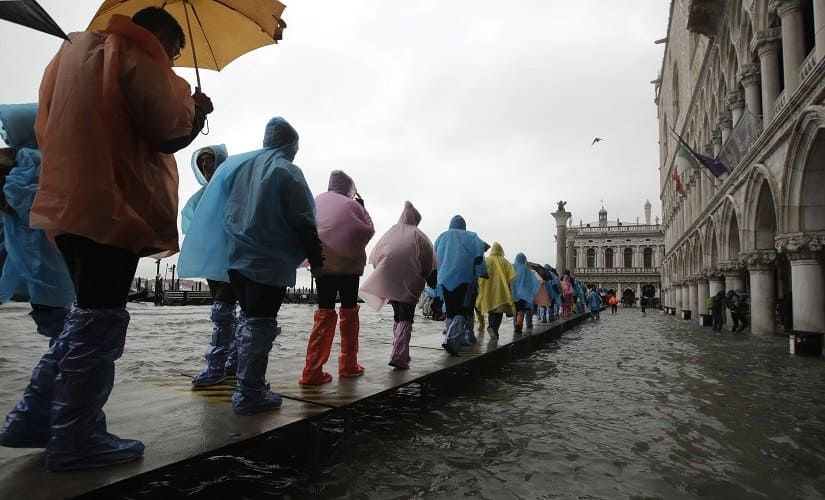 People walk on catwalk set up on the occasion of a high tide in Venice. AP