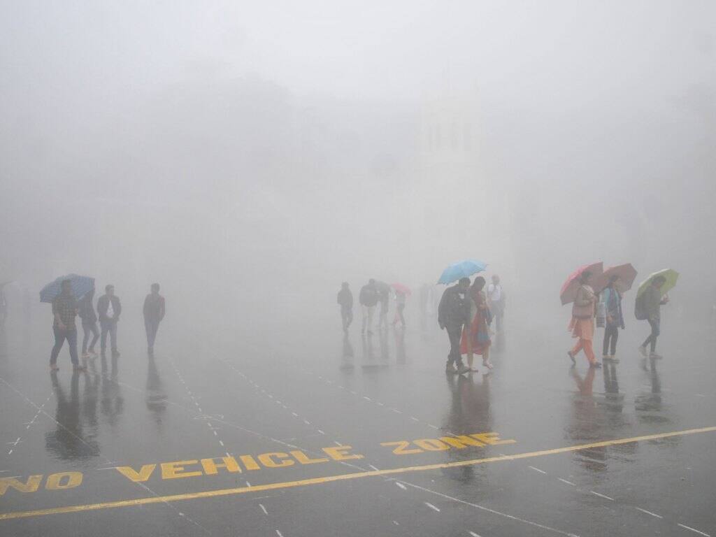 Commuters walk through fog as they hold umbrellas during a rainfall in Shimla in the India’s northern state of Himachal Pradesh on 9 October 2019. Image: Getty/AFP