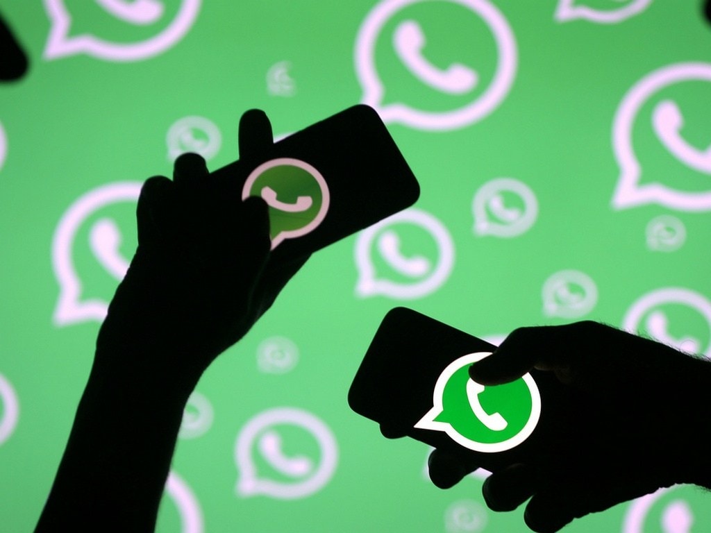 Men pose with smartphones in front of displayed Whatsapp logo in this illustration September 14, 2017. REUTERS/Dado Ruvic - RC1754A449A0