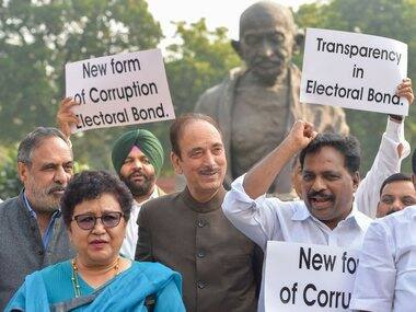 Congress MPs Ghulam Nabi Azad, Anand Sharma and others stage a protest over alleged electoral bond scam in front of the statue of Mahatma Gandhi in the Parliament premises. PTI