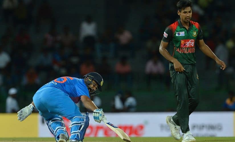 Indian cricket captain Rohit Sharma (L) runs between the wickets as Bangladesh cricketer Mustafizur Rahman look on during the fifth Twenty20 (T20) international cricket match between India and Bangladesh of the tri-nation Nidahas Trophy at the R. Premadasa stadium in Colombo on March 14, 2018. (Photo by LAKRUWAN WANNIARACHCHI / AFP)