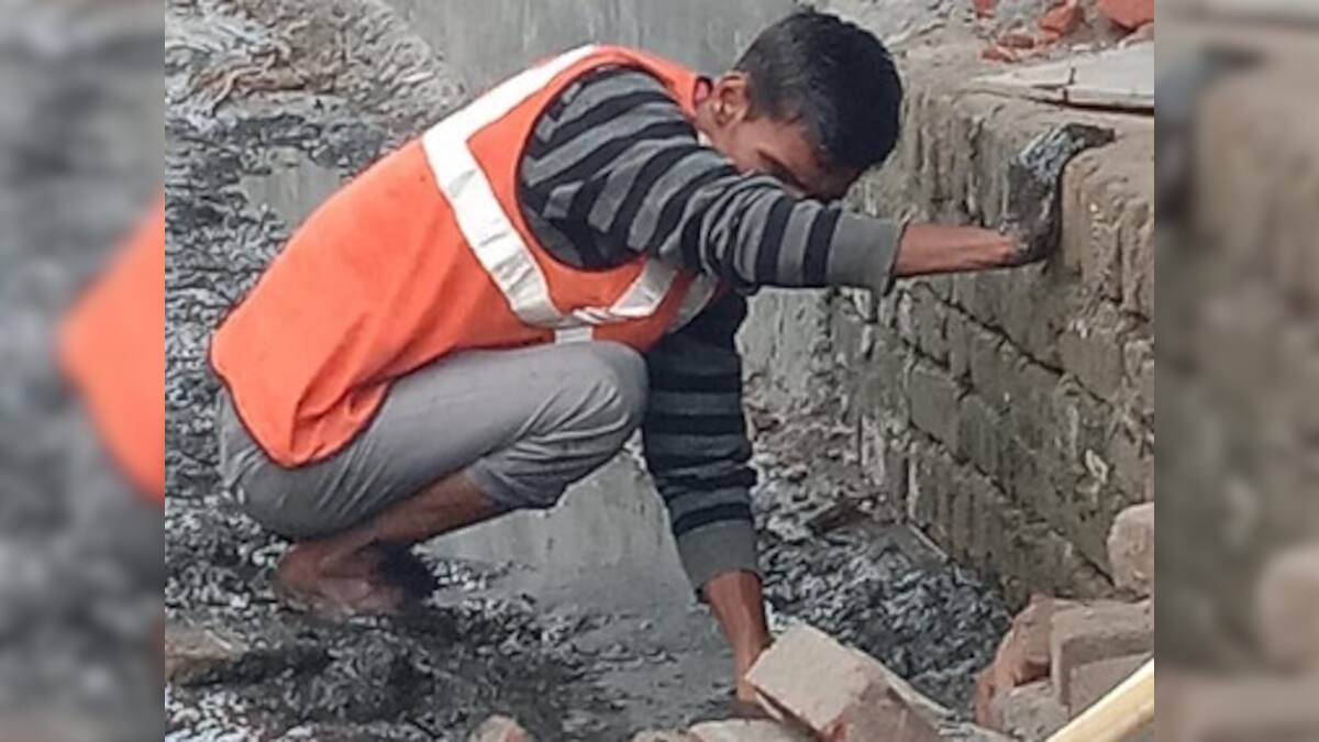 Pictures of sanitation workers in Noida cleaning drains without