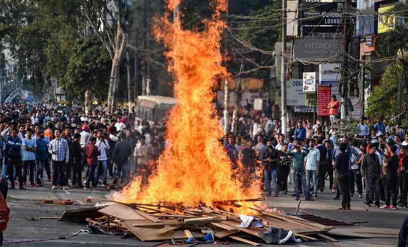 Protestors burn hoardings and other materials during their march against the Citizenship (Amendment) Bill, 2019 in Guwahati on Wednesday. PTI
