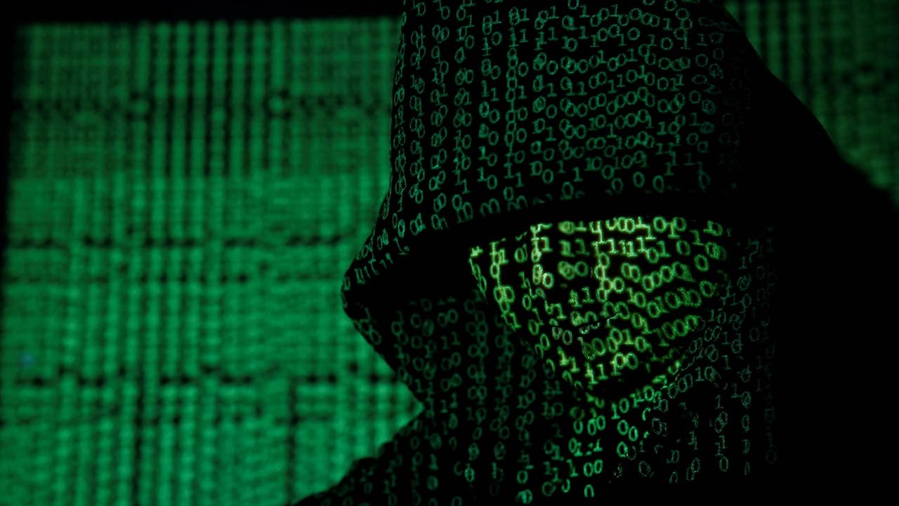 A projection of cyber code on a hooded man is pictured in this illustration picture taken on 13 May, 2017. Image: Reuters