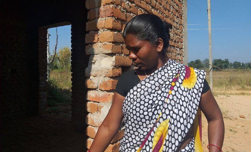Anita Minj, widow of Ramesh who was killed by a mob in Garhwa in August 2017, stands by her half-constructed house under the Awas Yojana. Firstpost/Natasha Trivedi