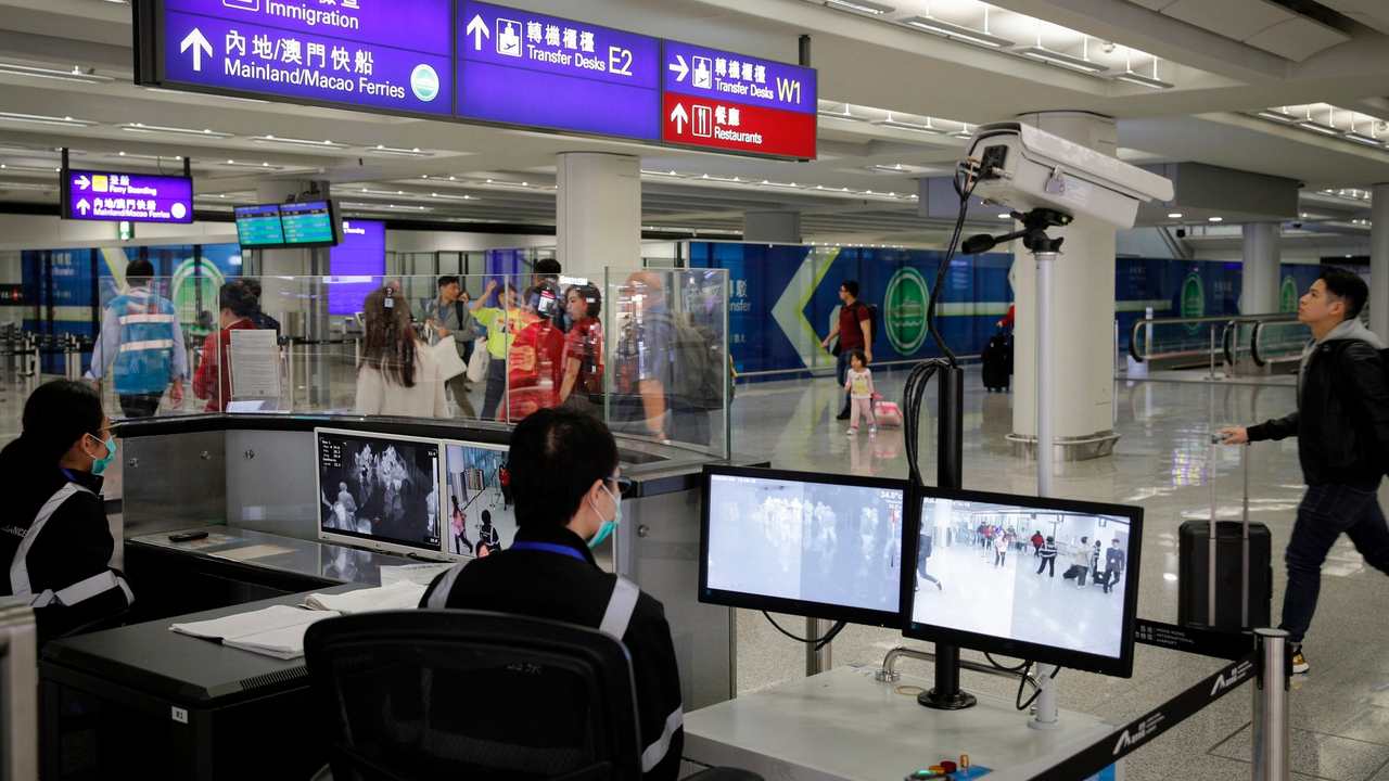 health surveillance officer use temperature scanner to monitor passengers arriving at the Hong Kong International airport in Hong Kong. The possibility that a new virus in central China could spread between humans cannot be ruled out, though the risk of transmission at the moment appears to be low, Chinese officials said. Image credit: AP