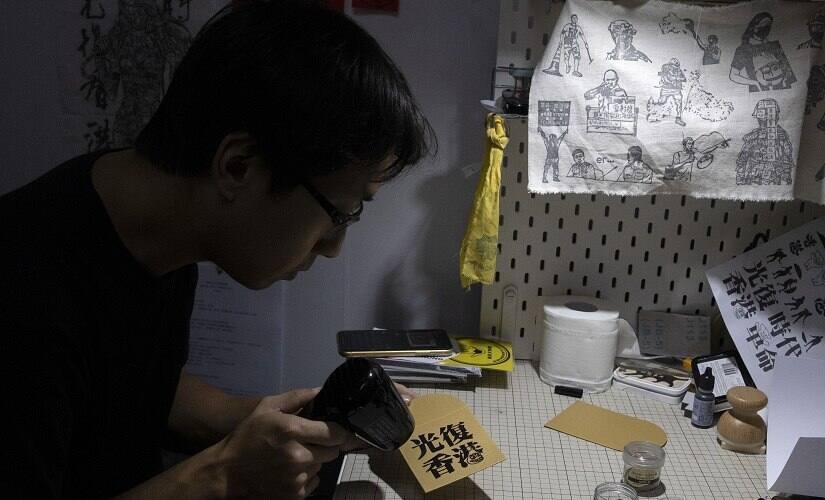 Sharing red packets stuffed with cash is an important Lunar New Year tradition. Printed messages generally convey wishes for prosperity and happiness, but Hong Kong's anti-government protests are putting a new spin on the tradition. Artist Kwan is designing politically themed rubber stamps so senders can add political messages. AP