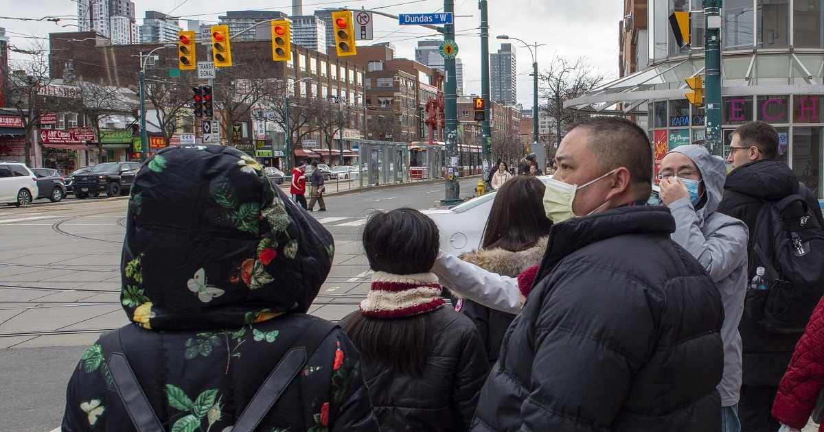 Pedestrians wear protective masks as they walk in Toronto on Monday, Jan. 27, 2020. Canada&rsquo;s first presumptive case of the novel coronavirus has been officially confirmed, Ontario health officials said Monday as they announced the patient&rsquo;s wife has also contracted the illness. (Frank Gunn/The Canadian Press via AP)