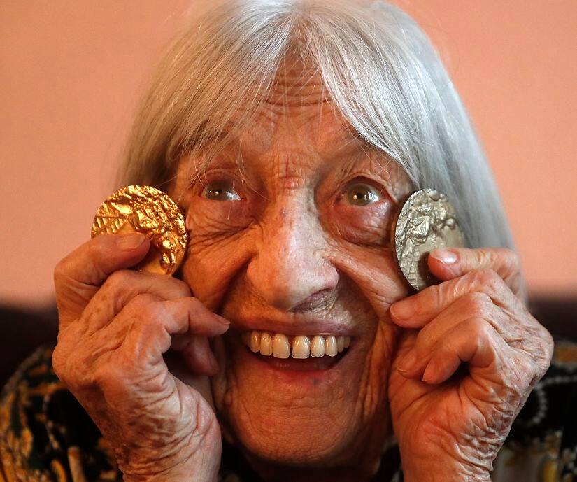 Agnes Keleti, former Olympic gold medal winning gymnast, poses for a photo with two of her Olympic medals at her apartment in Budapest. AP Photo