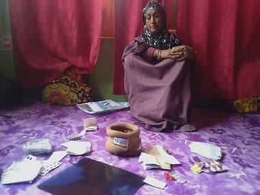: Zeeba Bano, wife of Abdul Rashid Dar, showing medicines she is taking for heart related diseases. Image procured by Quratulain Rehbar.
