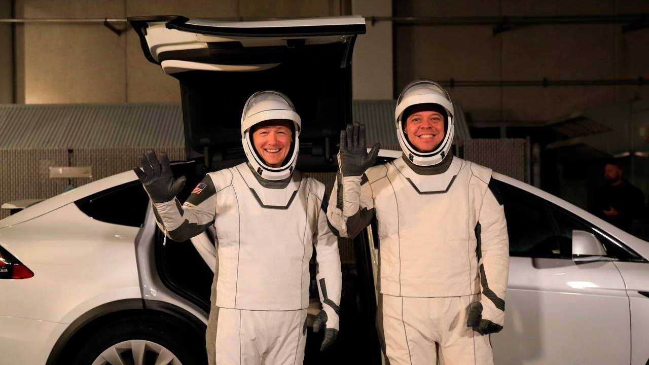 astronauts Doug Hurley, left, and Robert Behnken pose in front of a Tesla Model X at a SpaceX launch dress rehearsal, at Kennedy Space Center Image credit: AP