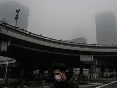 A man wearing a face mask crosses what is usually a busy street in Beijing on Thursday. By Gilles Sabrié © 2020 The New York Times 