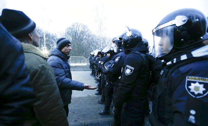 Protesters, who planned to stop buses with passengers evacuated from Wuhan, speak to Ukrainian riot police. AP