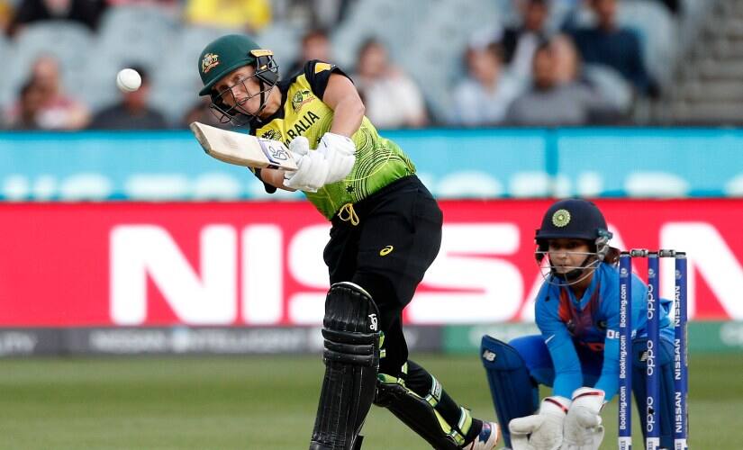 Australia’s Alyssa Healy, left, drives the ball in front of India’s Tanya Bhatia during the Women’s T20 World Cup final against India in Melbourne, Australia. AP