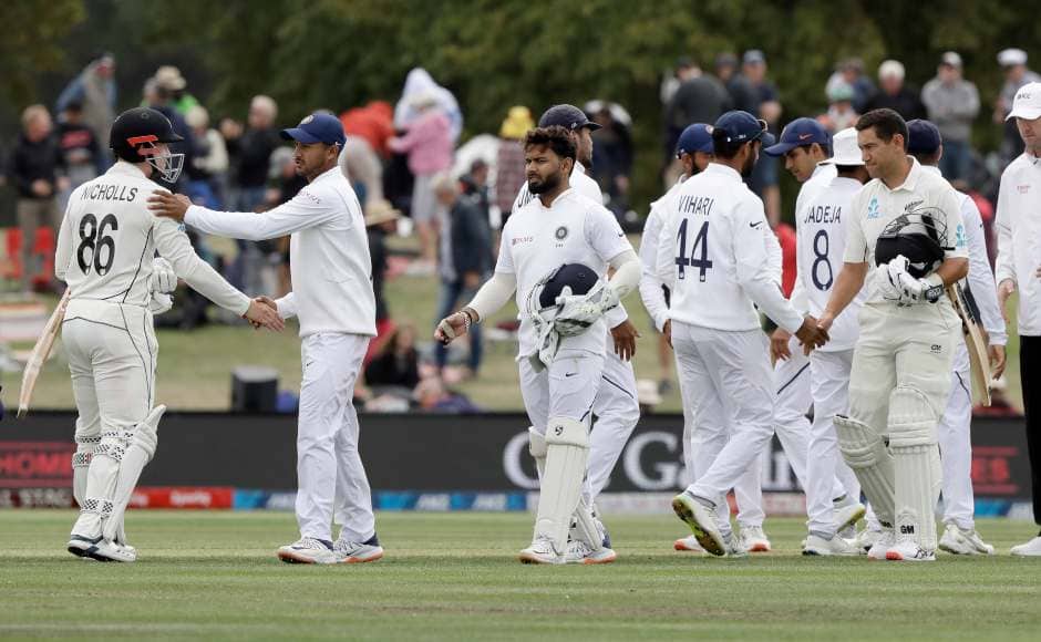 New Zealand and India players shake hands after the conclusion of the second Test. AP 