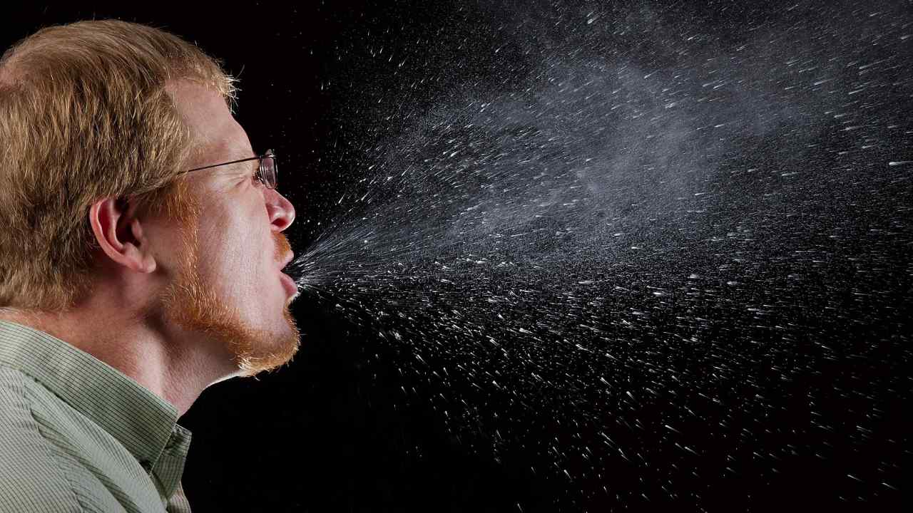 2009.Brian Judd..This 2009 photograph captured a sneeze in progress, revealing the plume of salivary droplets as they are expelled in a large cone-shaped array from this mans open mouth, thereby, dramatically illustrating the reason one needs to cover hios/her mouth when coughing, or sneezing, in order to protect others from germ exposure...How Germs SpreadIllnesses like the flu (influenza) and colds are caused by viruses that infect the nose, throat, and lungs. The flu and colds usually spread from person to person when an infected person coughs or sneezes.How to Help Stop the Spread of GermsTake care to: - Cover your mouth and nose when you sneeze or cough -  Clean your hands often - Avoid touching your eyes, nose or mouth -  Stay home when you are sick and check with a health care provider when needed - Practice other good health habits.