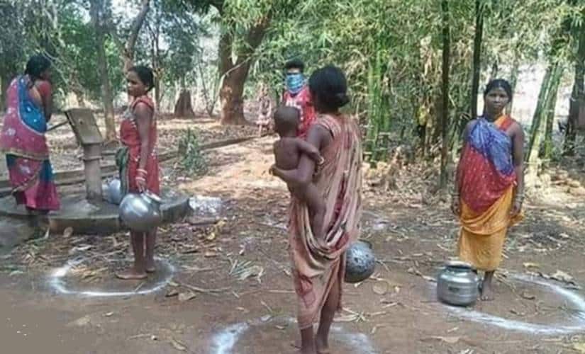 Adivasi women in Bastar maintaining social distancing while fetching water from a public borewell. Image procured by Debobrat Ghose/Firstpost