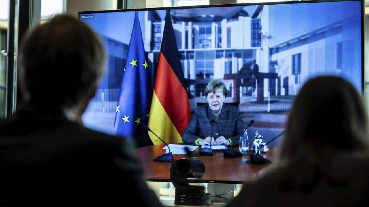 German Chancellor Angela Merkel displayed on a screen at the Environment Ministry as she delivers her speech at the Petersberg Climate Dialogue, in Berlin, Germany, Tuesday, April 28, 2020. Due to the coronavirus crisis, the conference will only be held digitally. (Michael Kappeler/Pool via AP)