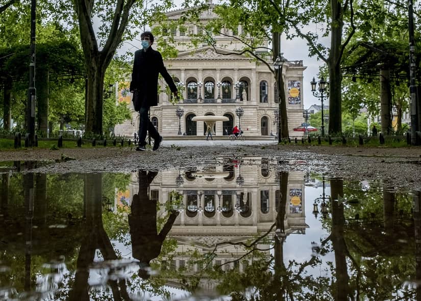 A man with a face mask walks in front of the Old Opera in Frankfurt, Germany. AP Photo