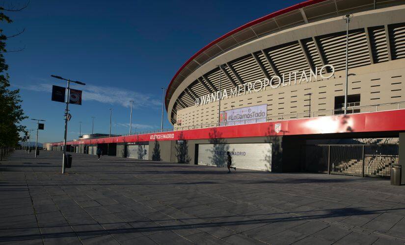A man jogs past Atletico Madrid’s Wanda Metropolitano stadium in Madrid, Spain, Tuesday, May 5, 2020. The Spanish soccer league aims to restart in June without spectators. It's new compulsory protocols say all players, coaches and club employees must be tested for COVID-19 coronavirus before training resumes, then regularly after that. All clubs’ training facilities must be properly prepared and disinfected before players can start practising individually. (AP Photo/Paul White)