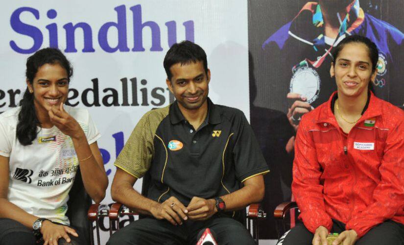 India badminton players PV Sindhu (L) and Saina Nehwal (R) look on as their coach Gopichand (C) speaks. AFP