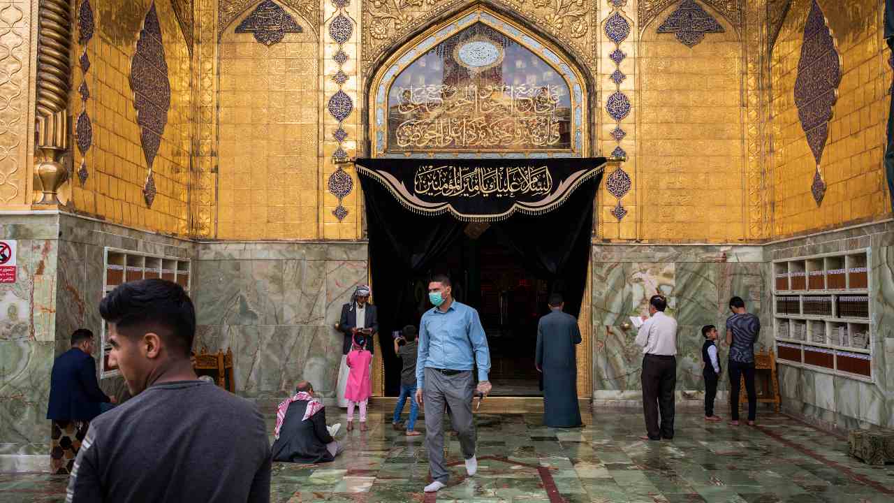 FILE – A security guard wearing a mask, at the entrance to the Shrine of Imam Ali in Najaf, Iraq, March 12, 2020. The coronavirus has touched almost every country on earth, but its impact has seemed capricious as global metropolises like New York, Paris and London have been devastated, while teeming cities like Bangkok, Baghdad, New Delhi and Lagos have, so far, largely been spared. (Ivor Prickett/The New York Times)