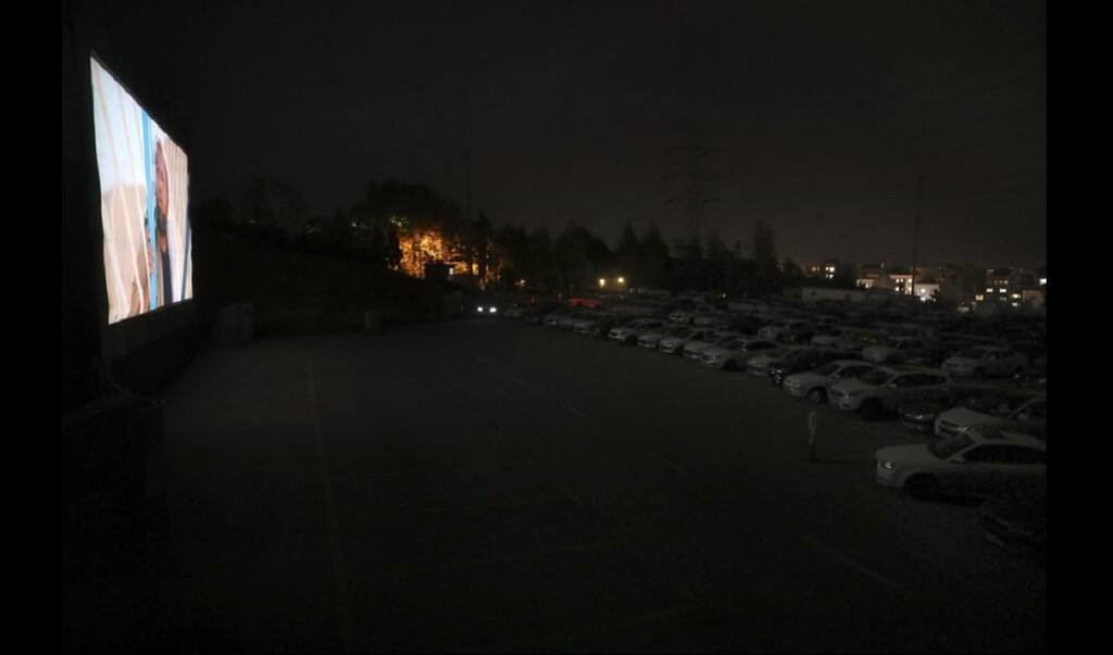 People sit in their cars watching a movie at a new drive-in cinema on a car parking area of the Milad telecommunications tower, as regular theaters are closed due to the coronavirus outbreak, Friday, May 1, 2020. Iran is the region’s epicenter of the COVID-19 pandemic. (AP Photo/Vahid Salemi)