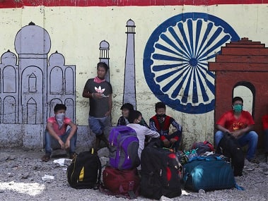 Migrant workers wait outside a railway station hoping to be able to return to their home states, in Mumbai. AP