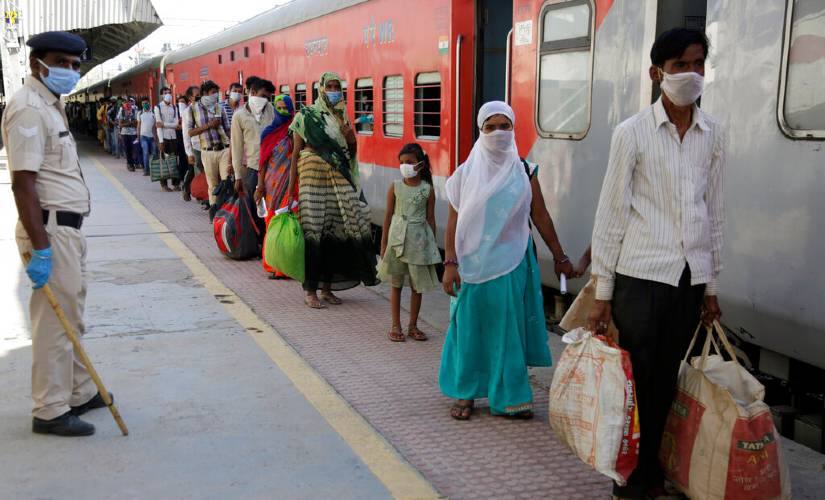 Migrant workers wait to board a special train to Agra in Uttar Pradesh at a railway station in Ahmedabad in Gujarat. AP