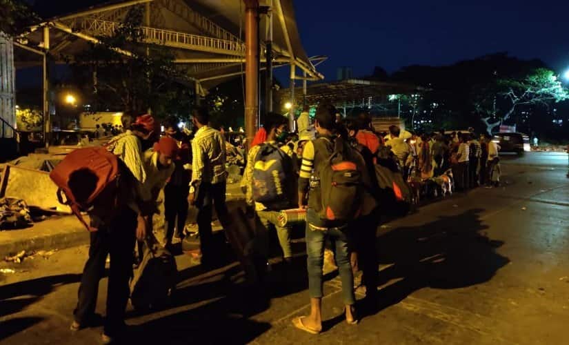 Tanned and exhausted, the workers sat in a queue with their worn out bags, sparingly drinking from their last bottle of water. Image/Parth MN