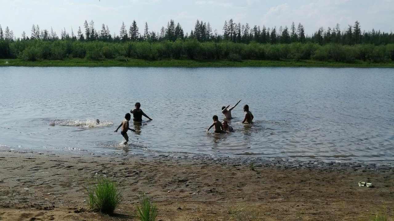 children play in the Krugloe lake outside Verkhoyansk, the Sakha Republic, about 4660 kilometers (2900 miles) northeast of Moscow, Russia, Sunday, June 21, 2020.  Image credit; Olga Burtseva via AP