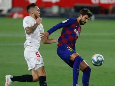 CORRECTING NAMES OF BOTH PLAYERS : FC Barcelona’s Gerard Pique, right, and Sevilla’s Lucas Ocampos in action during the Spanish La Liga soccer match between Sevilla and FC Barcelona at the Ramon Sanchez-Pizjuan stadium in Seville, Spain, Friday, June 19, 2020. (AP Photo/Angel Fernandez)