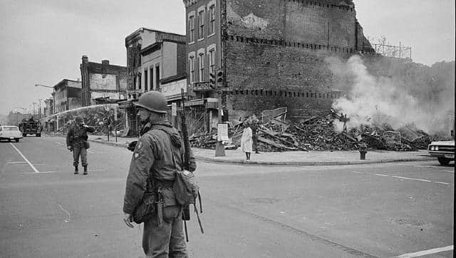A soldier standing guard at a badly-hit Washington DC neighbourhood after the riots of April 1968. Image courtesy: Library of Congress Prints and Photographs Division Washington, DC, WM