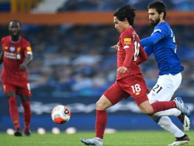 Everton's Andre Gomes, right, chases Liverpool's Takumi Minamino during the English Premier League soccer match between Everton and Liverpool at Goodison Park in Liverpool, England, Sunday, June 21, 2020. (Peter Powell/Pool via AP)