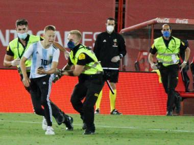 A supporter invades the pitch during the Spanish La Liga soccer match between Mallorca and FC Barcelona at Son Moix Stadium in Palma de Mallorca, Spain, Saturday, June 13, 2020. With virtual crowds, daily matches and lots of testing for the coronavirus, soccer is coming back to Spain. The Spanish league resumes this week more than three months after it was suspended because of the COVID-19 pandemic. (AP Photo/Francisco Ubilla)