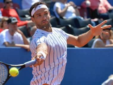 In this photo taken Saturday, June 20, 2020, Grigor Dimitrov from Bulgaria returns the ball to Croatia's Borna Coric during their semifinal match at a tournament in Zadar, Croatia. Dimitrov says he has tested positive for COVID-19 and his announcement led to the cancellation of an exhibition event in Croatia where Novak Djokovic was scheduled to play on Sunday. (AP Photo/Zvonko Kucelin)
