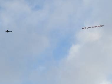 A plane towing a banner reading White Lives Matter Burnley flies above the stadium during the during the English Premier League soccer match between Manchester City and Burnley at Etihad Stadium, in Manchester, England, Monday, June 22, 2020. (AP Photo/Michael Regan,Pool)
