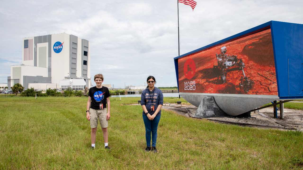 Students Alex Mather, at left, and Vaneeza Rupani, stand near the countdown clock at the News Center at NASA’s Kennedy Space Center in Florida on July 28, 2020. Alex was selected to name the Perseverance rover, and Vaneeza named the Ingenuity helicopter. Image credit: NASA/Kim Shiflett