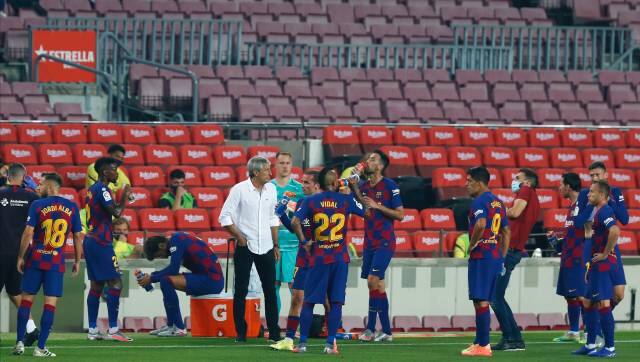 Barcelona's head coach Quique Setien, center, talks with his players during the Spanish La Liga soccer match between FC Barcelona and Athletic Bilbao at the Camp Nou stadium in Barcelona, Spain, Tuesday, June 23, 2020. (AP Photo/Joan Monfort)