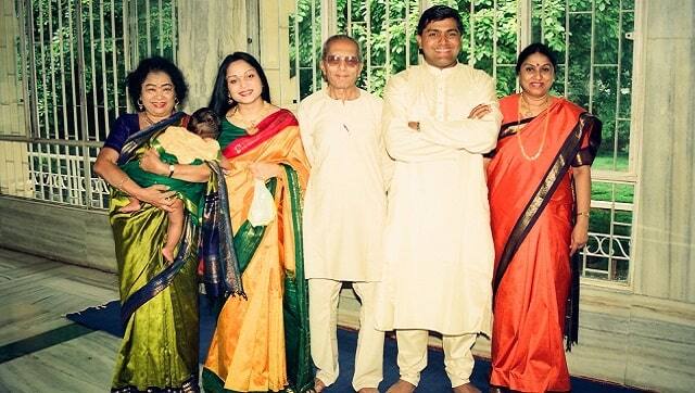 Shakuntala Devi is seen holding her elder granddaughter Amritha at a function. She's joined by her daughter Anupama, her husband Ajay and her in-laws.