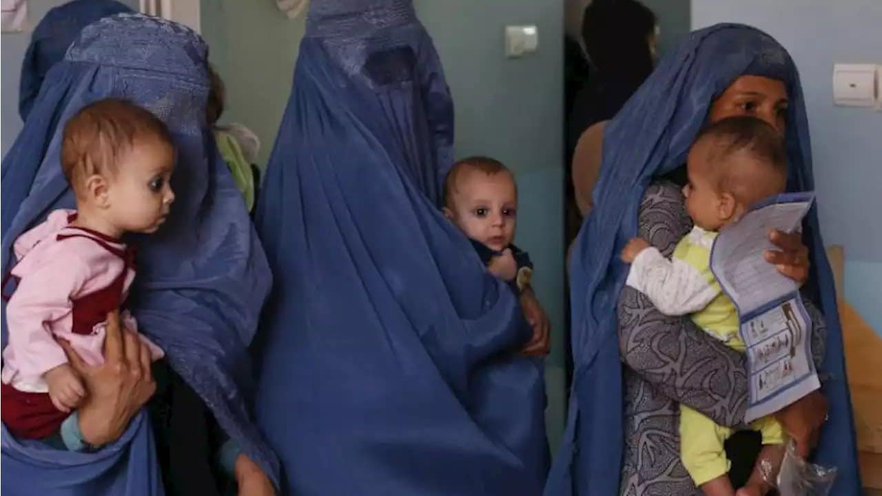 In this Aug. 26, 2019 photo, mothers hold their babies suffering from malnutrition as they wait at a UNICEF clinic in Jabal Saraj, north of Kabul, Afghanistan. In Afghanistan, severe childhood malnutrition spiked from 690,000 in January 2020 to 780,000 — a 13% increase, according to UNICEF. Food prices have risen by more than 15%, according to the World Food Program. (AP Photo/Rafiq Maqbool)
